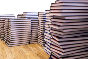 Stacks of books on a wooden table, isolated on a white background.