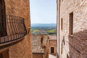 Panoramic view of the ancient houses of Assisi. View of the Umbrian countryside between the streets...