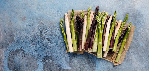 Green, white and purple asparagus on a kitchen background - 500458163