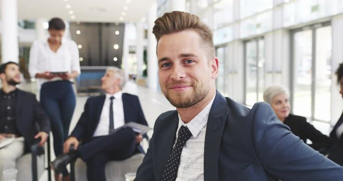 Im closer than I was yesterday. 4k video footage of a young businessman smiling in an office with his colleagues in the background.