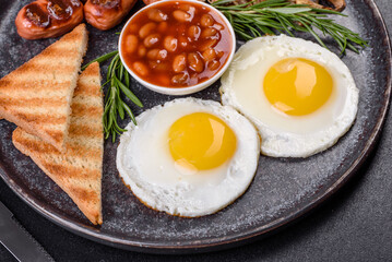 Full english breakfast with bean, fried eggs, roasted sausages, tomatoes and mushrooms