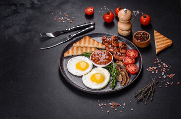 Full english breakfast with bean, fried eggs, roasted sausages, tomatoes and mushrooms