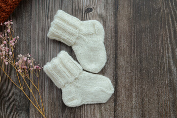 Obraz na płótnie Canvas Small woolen baby socks, on dark wooden background