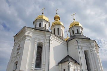 Fototapeta na wymiar Catherine's Church is a functioning church in Chernihiv, Ukraine. St. Catherine's Church was built in the Cossack period. Golden domes against the sky.