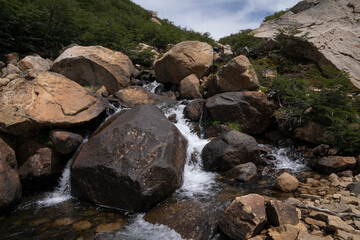 Naklejka na ściany i meble View of the fresh water stream flowing across the rocky mountain. 