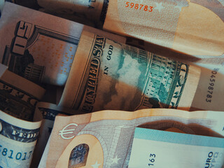 Cash banknotes dollars and euros are mixed up, a close-up shot.