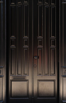 Black wooden door with a black handle. Wood texture. Concept Minimalism and luxury. Closed door background