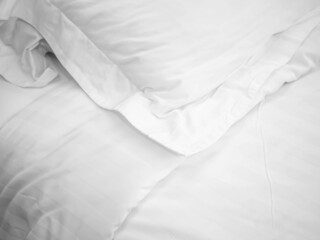 Closeup of wrinkle pillow and blanket on bed in bedroom for room service in hotel, housekeeping,...