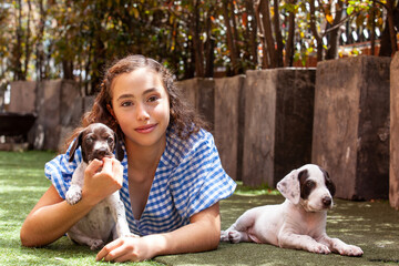Beautiful young girl having fun with her small French Braque puppies
