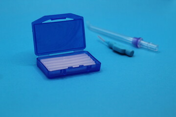 Orthodontic wax and hygiene equipment. Blue color. Copy space.