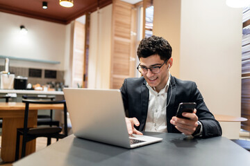 A manager in a business suit working office, using a laptop responds to a client's email