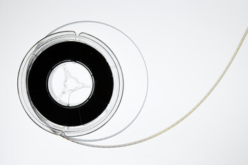 Film reel and strip on white, real 8mm old vintage movie unrolled