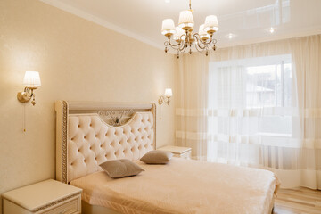 beautiful retro bedroom interior with a large classic bed with a soft headboard.