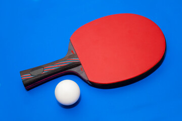 A ping pong racket on a uniform background with a table tennis ball. Free space for text. Sports equipment and ping pong game.