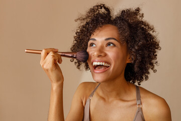 Charming multiracial woman posing against beige wall