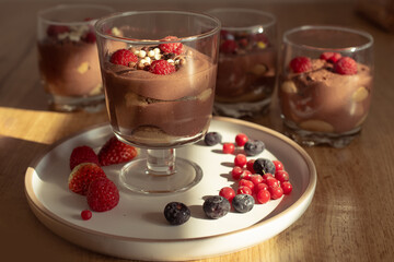 Chocolate mousse with raspberries and strawberries in a glass