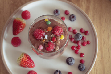 Chocolate mousse with raspberries and strawberries in a glass