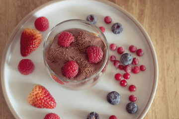 Chocolate mousse with raspberries and strawberries in a glass