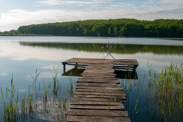 fisherman with fishing rods at sunrise on the lake