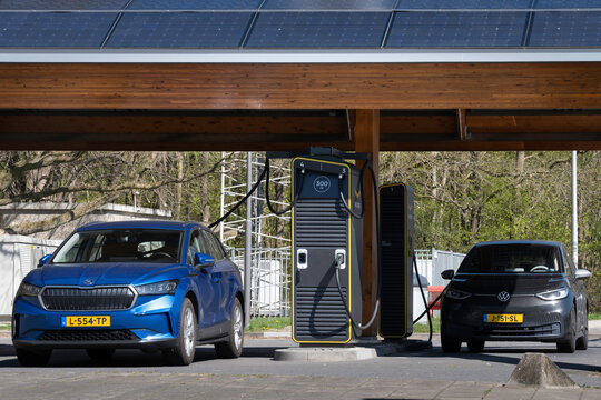 HEERDE, NETHERLANDS - APRIL 20 2022: Electric transport. Quickly charge a two cars with electricity at a public charging station in the fast-growing car charging network of Fastned in the Netherlands