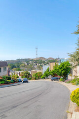 Naklejka premium Asphalt road with parked vehicles on a sloped residential area in San Francisco, California