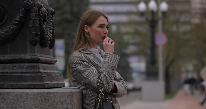 Woman smoking electronic cigarette, vape in the city