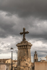 Gro&szlig;er Grabstein mit einem Kreuz vor dunklen Wolken
Friedhof auf Spaniens Insel Palma de Mallorca