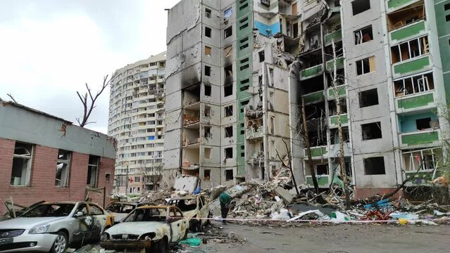 Chernihiv, Ukraine - April 17, 2022: The consequences of an air strike on a residential area and the civilian population of the city. A man walks past a destroyed apartment building in Ukraine.