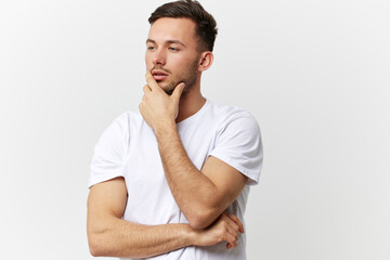 Pensive thoughtful sad tanned handsome man in basic t-shirt touch chin look aside posing isolated on over white studio background. Copy space Banner Mockup. People emotions Lifestyle concept