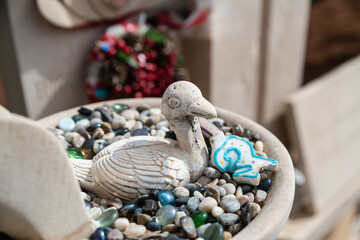 Eine Ente im Kiesbett neben einem Grab auf einem Friedhof  der Insel Mallorca