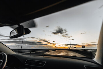 A trip in a car, travel on the highway in the evening. View from the front window on nature,...