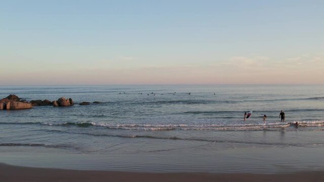 Drone footage of surfers at golden hour