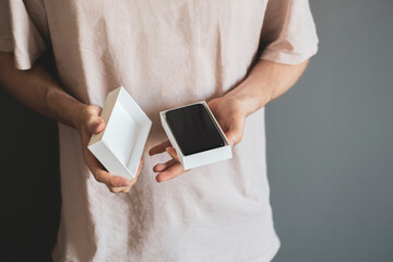 person holds the new smartphone box or case and unpack it, holiday surprise present concept
