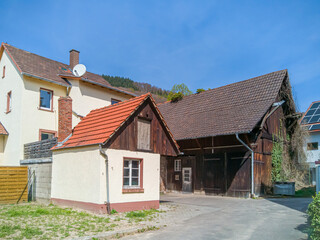 old barn buildings on the outskirts of a small german town remind of former agricultural uses