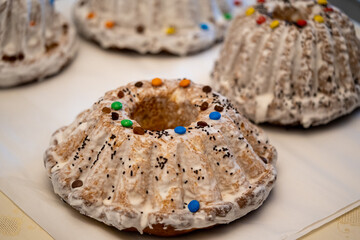 homemade Easter cake frosted with icing, decorated with colorful candies and boxwood leaves