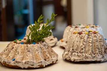 homemade Easter cake frosted with icing, decorated with colorful candies and boxwood leaves