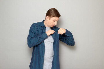 Portrait of surprised man looking with curiosity inside chest pocket