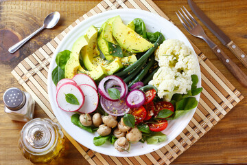 Ketogenic, paleo and vegan diet plate, avocado and vegetable salad on rustic wooden table. Vegetarian food, healthy eating