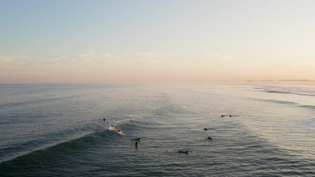 Drone footage of surfers at golden hour