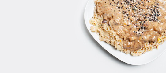 Vegan food. Close-up of homemade fettuccine pasta with Alfredo sauce on white.