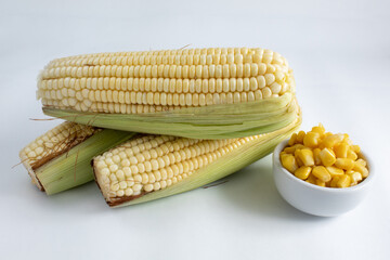 Corn on the cob, whole and in pieces, with corn kernels, in small ceramic bowl