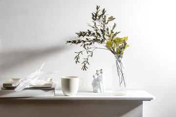 A vase with the dry branch of eucalyptus, wrinkled paper, a figurine of fox. Scandinavian style.