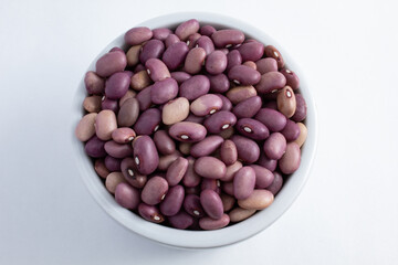 Brazilian purple beans seen from above in a white ceramic pot. Fresh, raw and healthy purple beans