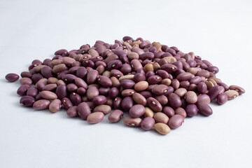 Portion of kidney beans still raw, fresh and healthy. Variety of Phaseolus vulgaris beans isolated on white background, brazilian purple beans