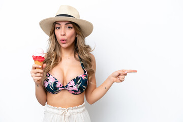 Girl wearing a swimsuit and holding cornet ice cream isolated on white background surprised and...