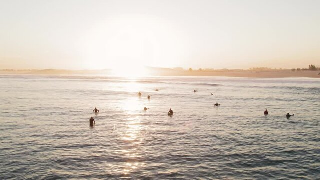 Drone footage of surfers at golden hour