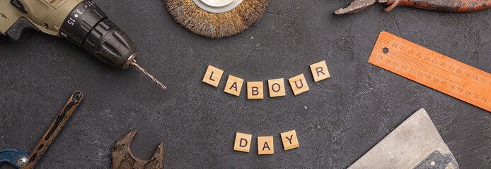 Labour day background concept - different construction tools on dark stone background