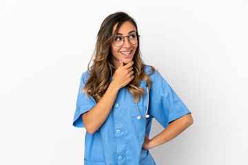 Young surgeon doctor woman over isolated white wall looking to the side