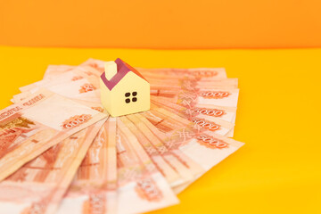 Home keys and a small house on currencies background. The concept of renting or selling house or flat, mortgage, investment or real estate, property buying. Money for the housing plan.rental concept.