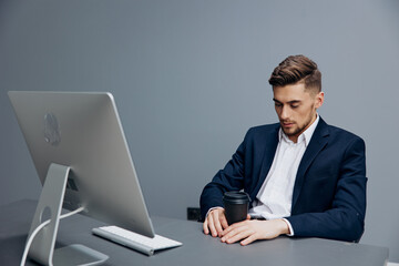 handsome businessman tired glass of coffee works in front of a computer office